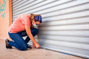 Person repairing garage door on Gold Coast, detailing repair costs and parts